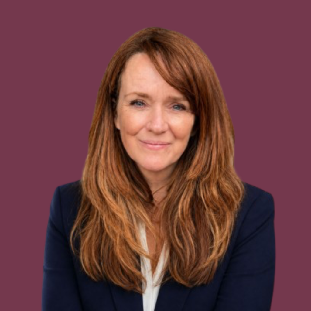 Angela Wilson, Founder and Director of Silver Apples Digital, wearing a navy blazer against a plum background.