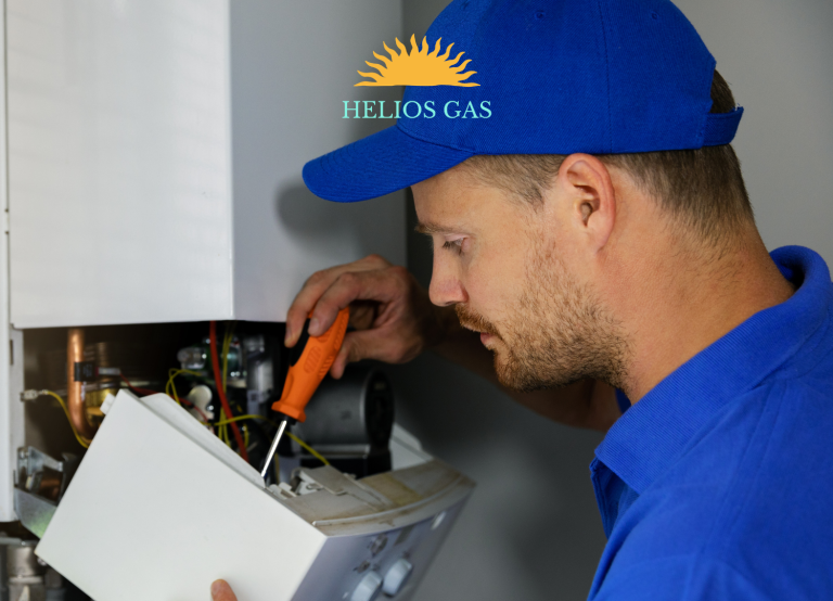 Helios Gas engineer wearing a blue uniform working on a domestic gas boiler, with the Helios Gas logo.